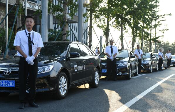 Drivers of cars provided by Didi wait outside a hotel in Dalian, Liaoning province. The ride-hailing firm is set to further expand overseas with the backing of major investors. (Photo by Chen Yihang/For China Daily)