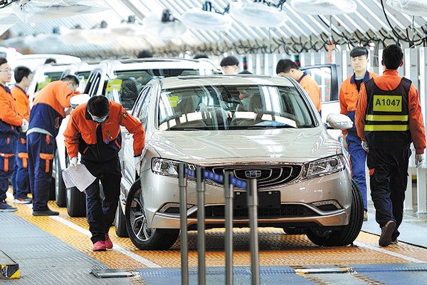 Workers check cars at a Geely production line in Ningbo, Zhejiang province.(Photo by Shi Yu/for China Daily)