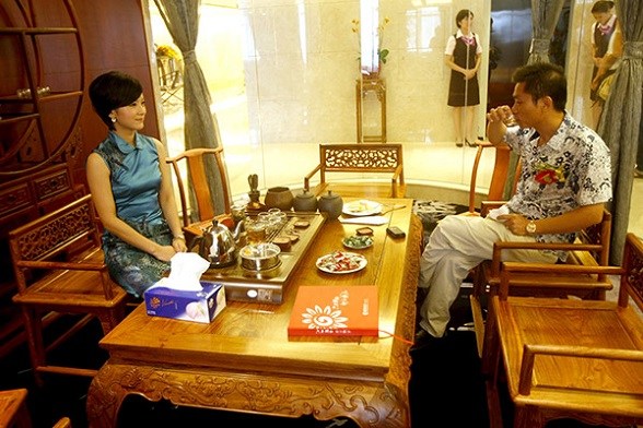 An employee (left) of China Merchants Bank explains various investment products of the bank to a client at the bank's private banking center in Dongguan, Guangdong province.(Photo provided to China Daily)
