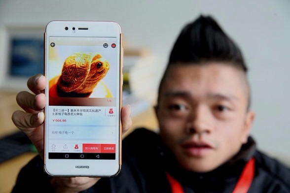 Yang Changguo shows an app developed by his company. (Photo provided to chinadaily.com.cn)