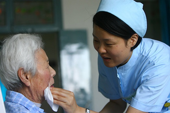 A nurse takes care of an elderly patient at a Kangning Hospital in Ningbo, Zhejiang province. The hospital belongs to the largest private psychiatric healthcare group in China.(Photo provided to China Daily)