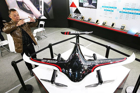 A visitor takes photographs of an SF logistics drone at a high-tech exhibition in Nantong, Jiangsu province. The company is stepping up efforts to build a drone network.(Photo by Xu Congjun/for China Daily)