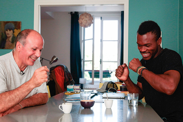Cameroonian refugee Emilien Atanga (right), 24, talks with Joel Elbaz, 57, the host who lent him an apartment through U.S. home-sharing website Airbnb on July 18, 2017, in Paris.(Photo provided to China Daily)