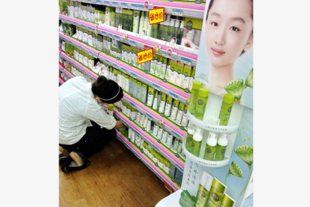 A saleswoman sorts out a display of Inoherb products at a supermarket in Shanghai. (Photo/hina Daily)
