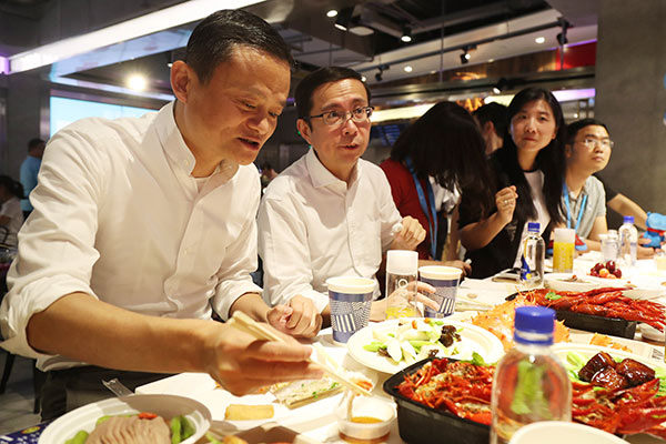 Jack Ma, the founder of Alibaba, savors the king crab he ordered at Hema Xiansheng, an emerging online-to-offline supermarket backed by Alibaba, in Shanghai in July. (Provided to China Daily)