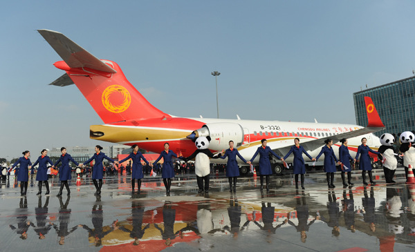Staff of Chengdu Airlines hail the arrival of the first ARJ21 regional jet delivered to the company, which flew from Shanghai to Chengdu, capital of Sichuan province, on Nov 29, 2015. (He Haiyang/for China Daily)