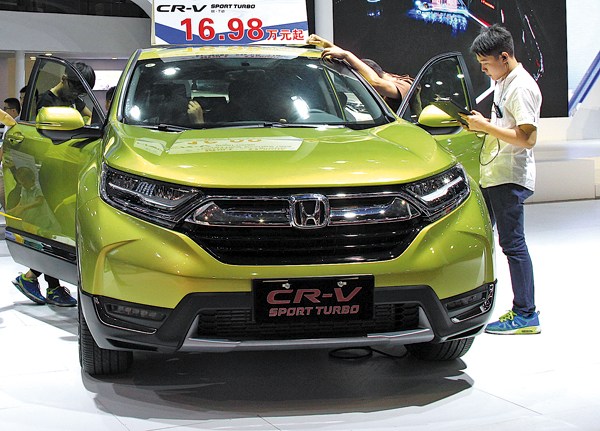 Visitors look at a Honda CR-V at an auto show in Dongguan, Guangdong province. (Photo provided to China Daily)