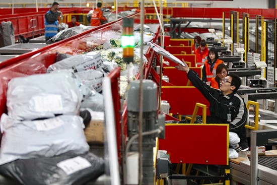 Workers of SF Express sort packages at an outlet of the company in Beijing. (Photo/China Daily by Zhu Xingxin)