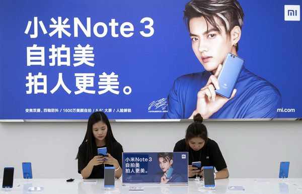 Employees of Xiaomi Corp test the company's gadgets at a product launch event in Beijing. (Photo provided to China Daily)