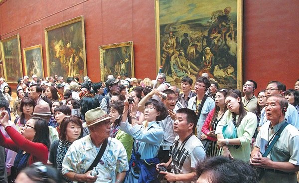 Crowds of Chinese tourists visit exhibitions at the Louvre Museum in Paris.  (China Daily/Jiang Dong)