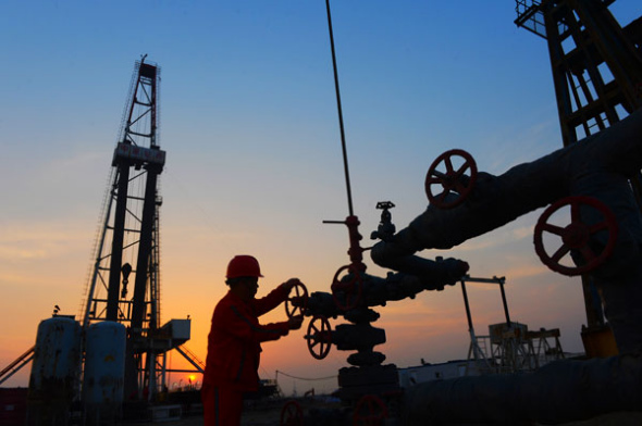 A CNPC employee switches on an oil transportation valve at a facility in Tangshan, Hebei province. (Photo/China Daily)