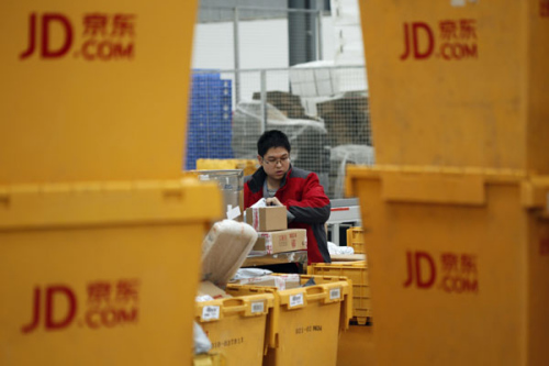 An employee of JD in Xi'an, Shaanxi Province, sorts delivery packages. (Photo by Jiao Hongtao/For China Daily)