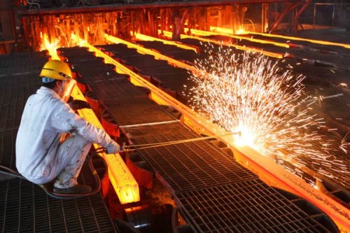 A worker cuts steel bars on the production line of a mill in Lianyungang, Jiangsu Province. (Photo/China Daily)