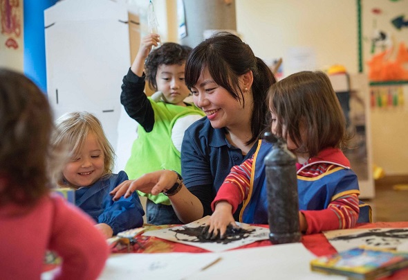 Chinese teacher plays with children at bilingual prep school Kensington Wade in London. (Photo provided to China Daily)