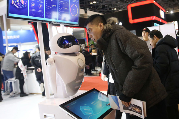 An AI-supported robot addresses queries from a visitor at the China Finance Annual Forum held in Beijing on Thursday. (Photo by Chen Xiaogen/For China Daily)