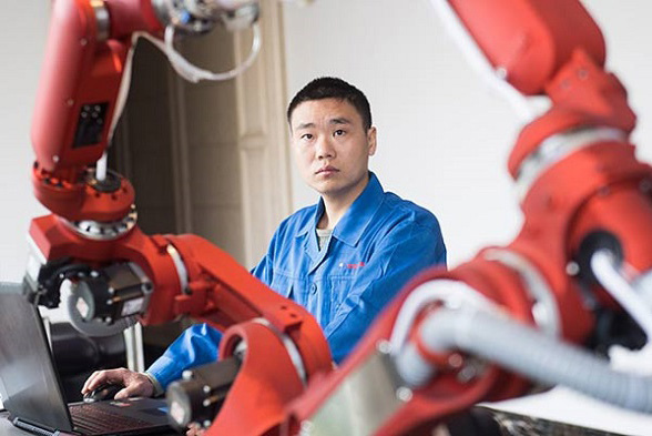 A technician from Hsoar Group, based in Wenzhou, Zhejiang province, adjusts a robot made by the company.(Photo/Xinhua)