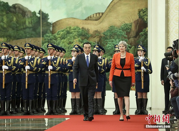 Premier Li Keqiang and British Prime Minister Theresa May review a Chinese honor guard during a welcoming ceremony at the Great Hall of the People in Beijing on Wednesday. (Liu Zhen/China News Service)