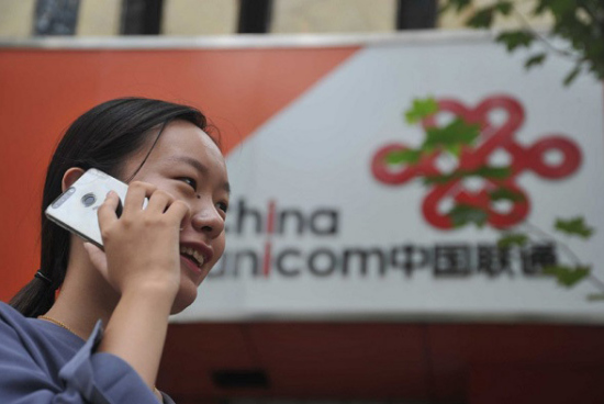 A customer uses her mobile phone outside an outlet of China Unicom in Yuncheng, Shanxi province. (Photo/Xinhua)