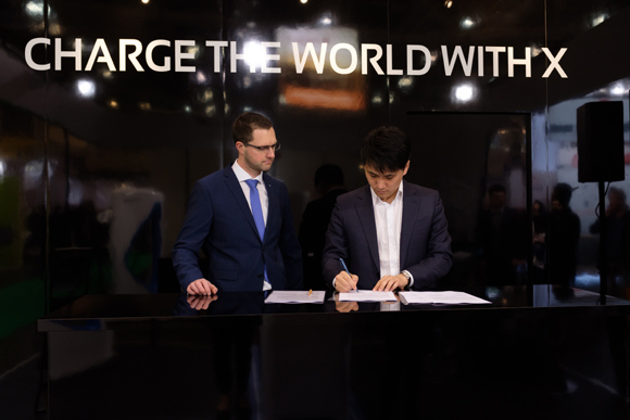 Marc Zapin, head of Laboratory Components Commercial in TV RHEINLAND (L) AND SIMON HOU, COO OF XCharge (R) sign the contact. (Photo provided to Ecns.cn)