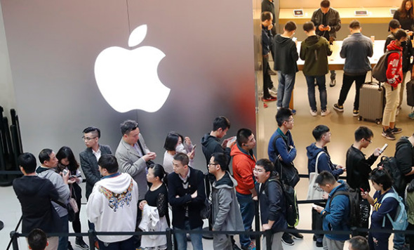 Customers line up outside an Apple store in Shanghai to buy iPhoneX handsets. (YIN LIQIN/CHINA NEWS SERVICE)