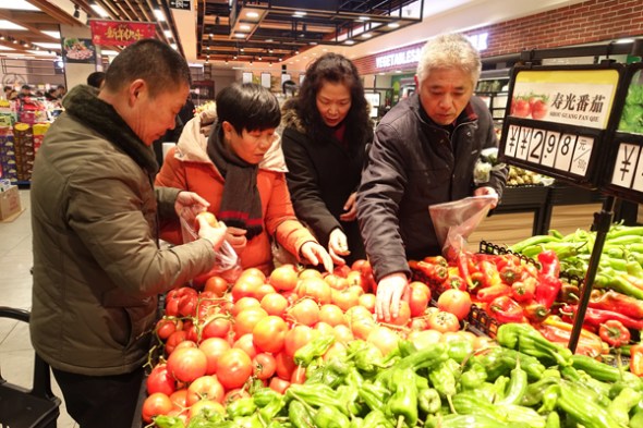 Residents select vegetables at a supermarket in Fuyang, Anhui province. (Photo by Wang Biao/For China Daily)