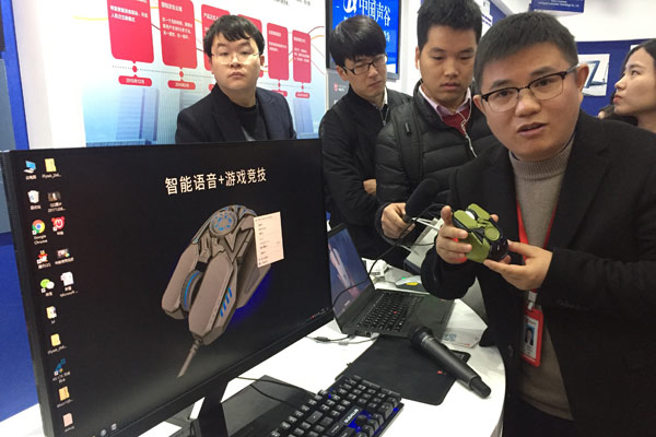 Feng Haihong, CEO of Anhui MiMouse Technology, introduces the company's intelligent voice-controlled mouse, which can type and translate, in Hefei, Anhui province, in December.(Photo by Wu Lan/ China News Service)