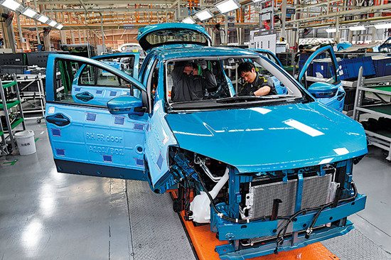 Workers assemble a car at Yudo New Energy Automobile, a large new energy auto manufacturer based in South China's Fujian province, on Dec 20, 2017. (Photo/Xinhua)