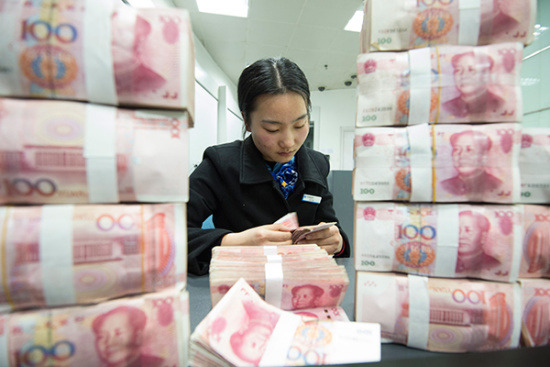 A clerk counts cash at a bank outlet in Hai'an county, Jiangsu province. (Photo/China Daily)