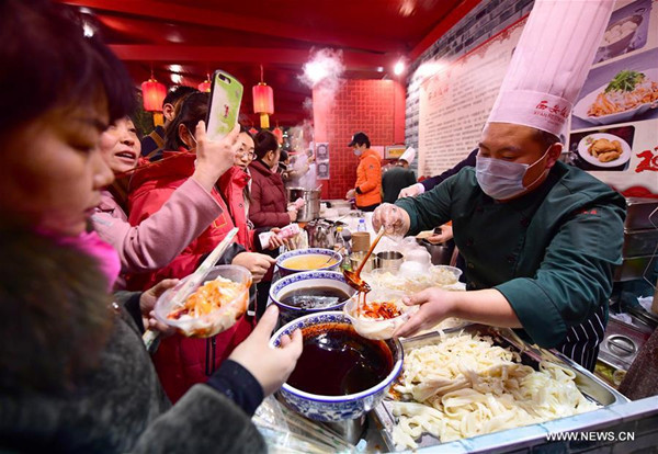 People buy cold noodles, a typical food of Xi'an, at a Spring Festival Fair in Xi'an, northwest China's Shaanxi Province, Feb. 19, 2018. Fairs were held at main scenic spots in Xi'an City to celebrate Spring Festival. (Xinhua/Shao Rui)