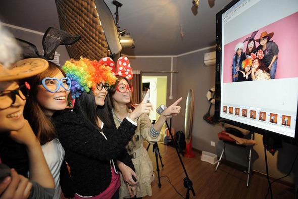 Customers choose pictures at a selfie studio in Chongqing. (Photo provided to China Daily)
