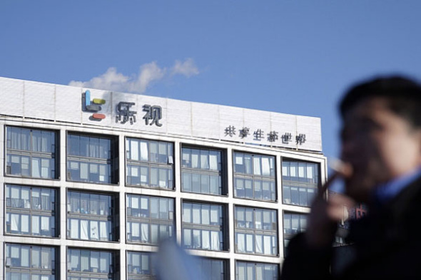 A man walks past the headquarters of internet company LeEco in Beijing.(Photo by Chen Weixi/ For China Daily)