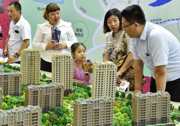 Prospective buyers inquire about a housing project at the 2016 Real Estate Fair at the Dalian World Expo Center in Liaoning province, Northeast China. (Photo provided to China Daily)