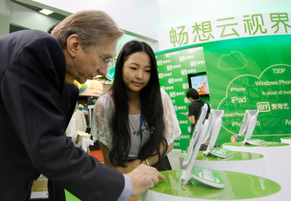 A foreigner watching video programmes on iQiyi at an expo held in Beijing. (Photo by A Jing/for China Daily)