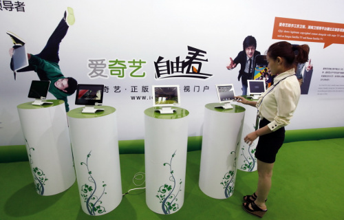 An employee highlights the salient features of the iQiyi online video streaming platform during a recent high-tech exhibition in Beijing. (Photo/China Daily)