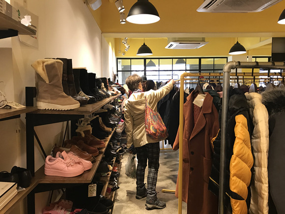 Customers shop at one of Buy42's six brick-and-mortar charity stores in Shanghai. (Photo: China Daily/He Qi)