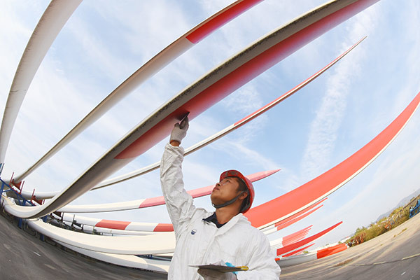 A worker checks the quality of wind turbine fans in Lianyungang, Jiangsu province. (Photo by Geng Yuhe/for China Daily)