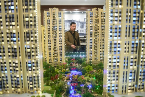 A prospective homebuyer looks at the model of a residential project at a property sales office in Taiyuan, Shanxi Province. (Photo/Xinhua)