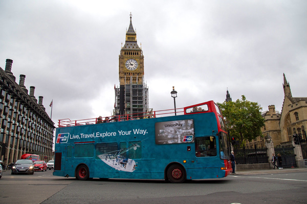 A bus carrying an advertisement for UnionPay's services passes through Parliament Square in London. (Photo provided to chinadaily.com.cn)