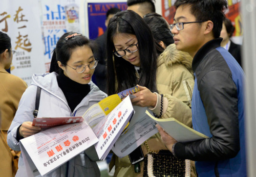 Job seekers check recruitment information at a job fair held in Hangzhou, capital of Zhejiang Province. (Photo by Shi Jianxue/For China Daily)
