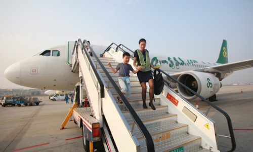 A Spring Airlines hostess escorts an unaccompanied child to the airport in Bangkok after a recent flight from Dalian, Liaoning Province. Photo provided to China Daily