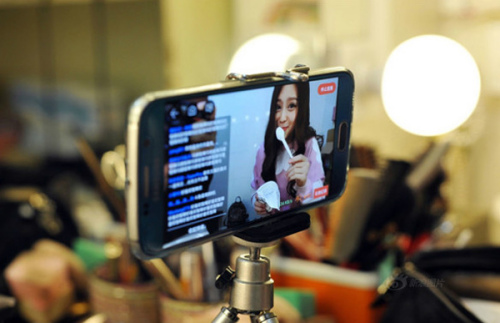 An online anchor uses her mobile phone to do live streaming. (Photo/Xinhua)