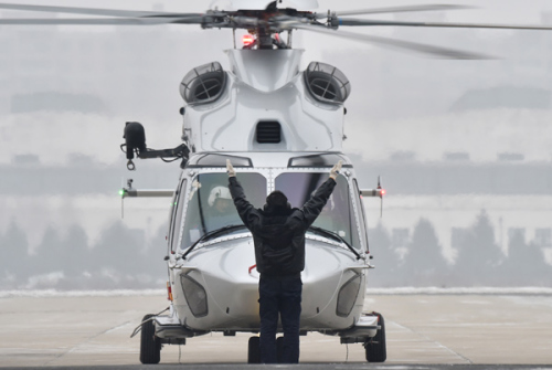 A ground personnel clears an AC352 helicopter, designed by the Aviation Industry Corporation of China, for take off. (Photo/Xinhua)