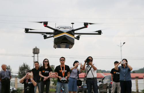 As officials, pilots and media people watch, a drone carrying mail of China Post takes off for its first service flight in Anji county, East China's Zhejiang Province, in September 2016. (Photo by Xiang Fei/For China Daily)