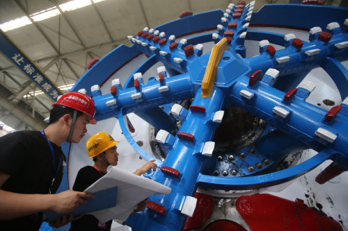 Two engineers from CRHIC check a railway tunnel-boring machine. (Photo provided to China Daily)