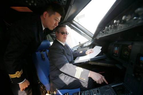 Paul Emerson Sommerfeld, a flight captain from the United States employed by China Eastern Airlines, talks with a Chinese colleague in 2016. (YIN LIQIN/FOR CHINA DAILY)