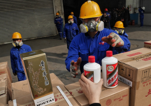 Inspectors take inventory of seized fake Moutai liquor that is about to be destroyed in Beijing on Tuesday. (WANG JIANING/FOR CHINA DAILY)