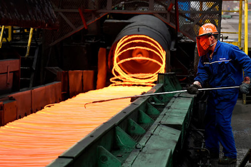 An employee checks steel rings at a steel plant in Zouping, Shandong Province. (Photo by Dong Naide/for China Daily)