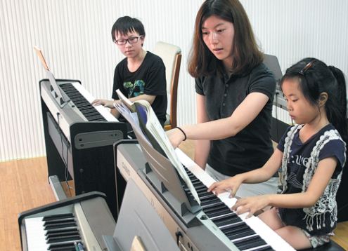 Children learn to play electronic organs at a children's center in Suzhou, East China's Jiangsu Province. (Photo by Wang Jiankang/for China Daily)