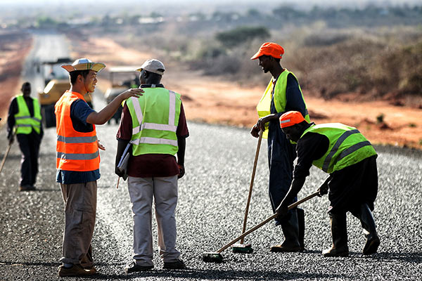 Construction workers level the surface of a road in Kenya's Marsabit district being built by China Wu Yi Co Ltd. (Photo/Xinhua)