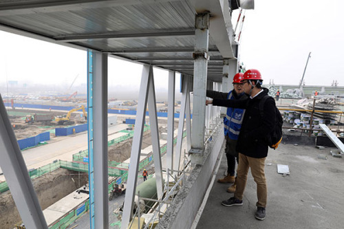 Architects work at the construction site of a residents' service center in Rongcheng county, Hebei Province, part of the Xiongan New Area. (Photo by Zhu Xingxin/China Daily)